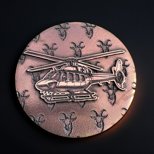 Bronze-colored coin with helicopter design and goat heads on a dark background